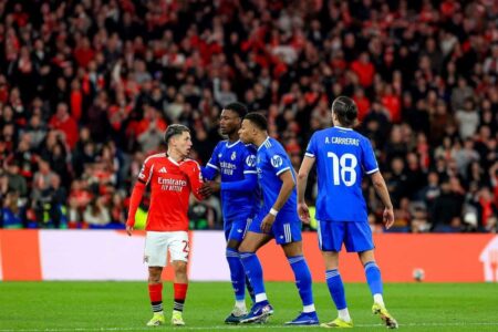 شعار نادي بنفيكا مع صورة للاعب جيانلوكا بريستياني وفينيسيوس جونيور في خلفية، يرمز لقضية الإيقاف والعنصرية.